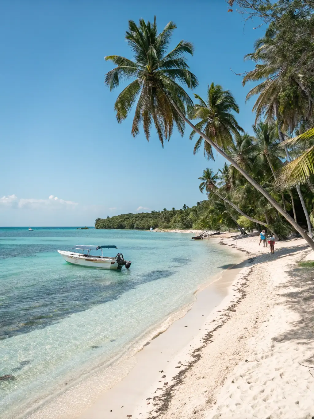 A picturesque shot of Rum Point, Grand Cayman, featuring its shallow, calm waters, swaying palm trees, and colorful beach chairs, creating a relaxing and inviting atmosphere. A great spot for families renting with Cayman Rentals.